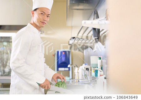 A man in a chef's hat looking at me with a smile A man in a chef's hat looking at me with a smile 106843649