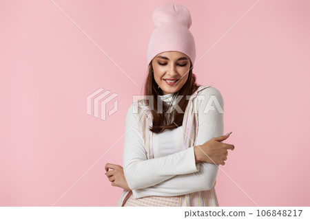 Happy playful young woman in pink hat, shirt and skirt Happy playful young woman in pink hat, shirt and skirt 106848217