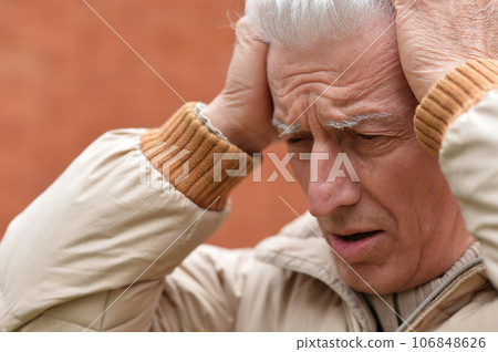 Portrait of an old man having a headache Portrait of an old man having a headache 106848626