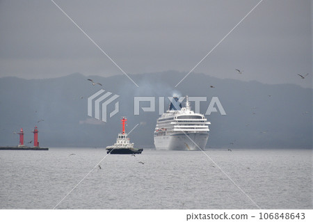 Photographing the scenery of the cruise ship Asuka II and the tugboat entering Hakodate Port, Hakodate City, Hokkaido in early autumn. 106848643