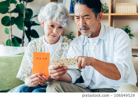 A senior couple thinking about retirement money in the living room 106849529