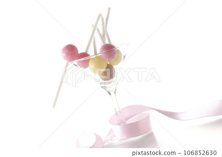 白色背景中拍攝的雞尾酒杯、糖果和絲帶 白色背景中拍攝的雞尾酒杯、糖果和絲帶 106852630