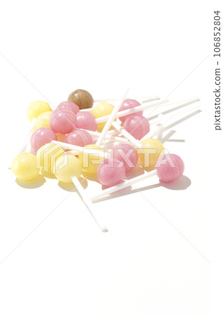 A photo of a spherical candy attached to a stick against a white background A photo of a spherical candy attached to a stick against a white background 106852804