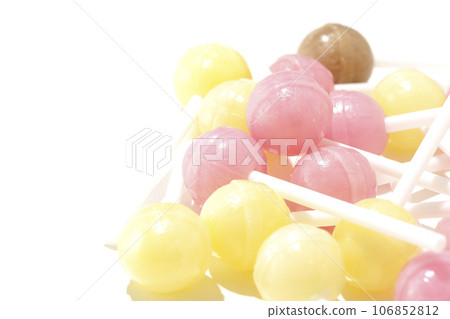 A photo of a spherical candy attached to a stick against a white background A photo of a spherical candy attached to a stick against a white background 106852812