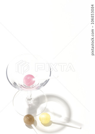白色背景中拍攝的雞尾酒杯和糖果 106853084