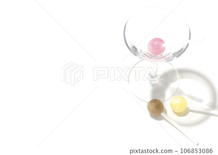 Cocktail glass and candy photographed on white background 106853086