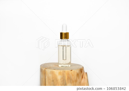 Natural oil cosmetics. Dropper glass Bottle Mock-Up. Oily cosmetic pipette. Face and body treatment. Spa concept. Mineral organic liquid. Front view. Beauty products. Blank packaging on wooden table 106853842