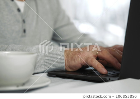 Closeup of senior man hands using laptop. Cropped side view of wrinkled caucasian older hands typing keyboard. Old people with technology. Unrecognizable retired male working from home sitting at desk Closeup of senior man hands using laptop. Cropped side view of wrinkled caucasian older hands typing keyboard. Old people with technology. Unrecognizable retired male working from home sitting at desk 106853856