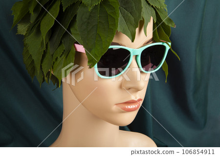 a display mannequin wearing hair of leaves and sunglasses 106854911