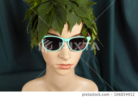 a display mannequin wearing hair of leaves and sunglasses 106854912