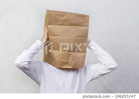 An anonymous man with a box on his head, constricting his identity. Hidden emotions. An anonymous man with a box on his head, constricting his identity. Hidden emotions. 106855247