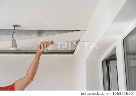 Worker assemble a suspended ceiling. Worker assemble a suspended ceiling. 106855630