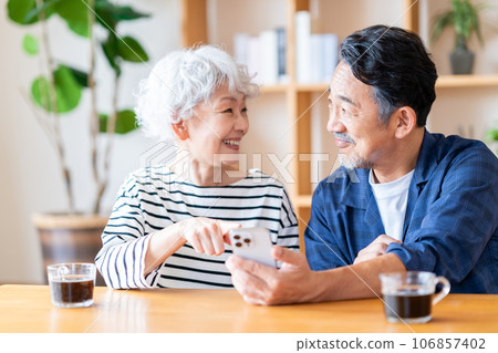 A senior couple looking at a smartphone together. A senior couple looking at a smartphone together. 106857402