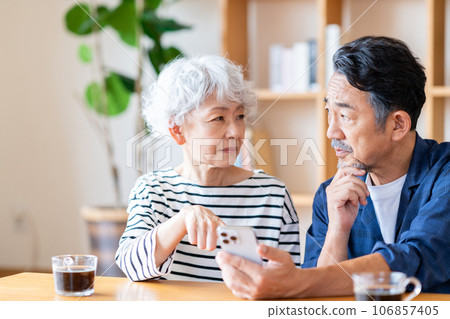 A senior couple looking at a smartphone together. A senior couple looking at a smartphone together. 106857405