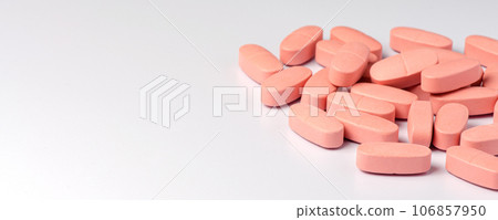 Pink calcium tablets on a white background. Copy space. Pink calcium tablets on a white background. Copy space. 106857950