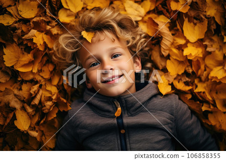 The boy lies in the autumn leaves 106858355