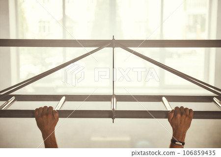 Cropped photo of a man doing pull-ups while exercising in the gym. 106859435