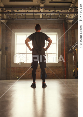 Sport is my lifestyle. Back view of young athletic man in sportswear standing at gym before training Sport is my lifestyle. Back view of young athletic man in sportswear standing at gym before training 106859436