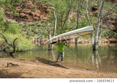 senior male is portaging  expedition canoe 106859613