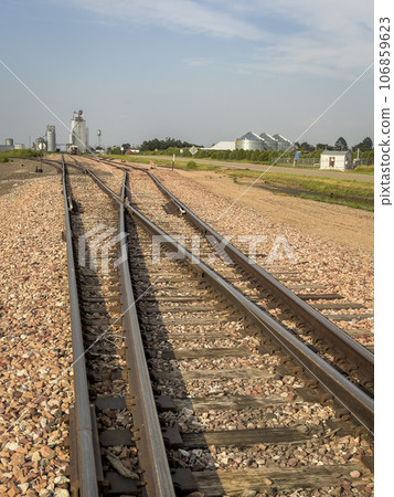 railroad tracks leading to silo and grain elevators in a rural town in Nebraska 106859623