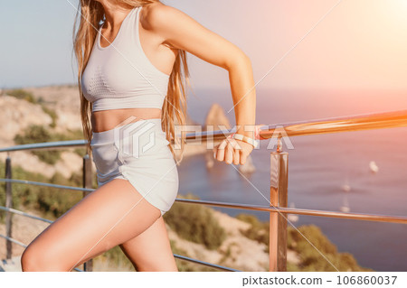 Fitness woman sea. Outdoor workout with fitness rubber bands in park over beach. Female fitness yoga routine concept. Healthy lifestyle. Happy fit woman exercising with rubber band in park. Fitness woman sea. Outdoor workout with fitness rubber bands in park over beach. Female fitness yoga routine concept. Healthy lifestyle. Happy fit woman exercising with rubber band in park. 106860037