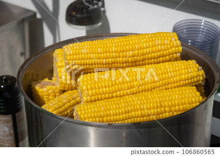 A street vendor cooks corn in a pot and sells it. Lots of sweet, delicious and boiled corn. 106860565