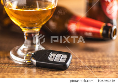 Car key with beer glass on wooden table. Booze driving concept. Drunk driver concept. 106860816