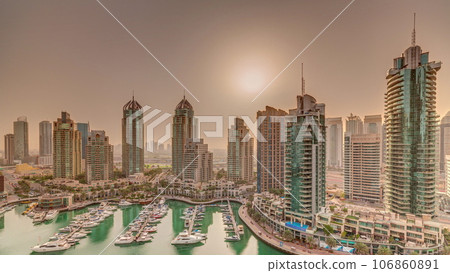 Sunrise over Dubai Marina luxury tourist district with skyscrapers and towers around canal aerial timelapse Sunrise over Dubai Marina luxury tourist district with skyscrapers and towers around canal aerial timelapse 106860891