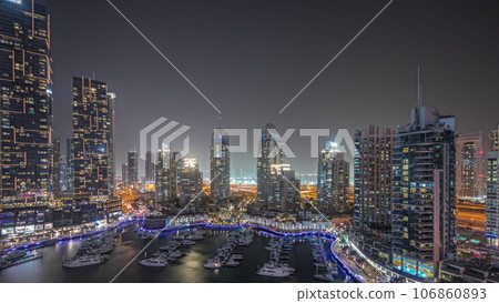 Panorama showing Dubai marina tallest skyscrapers and yachts in harbor aerial night timelapse. 106860893