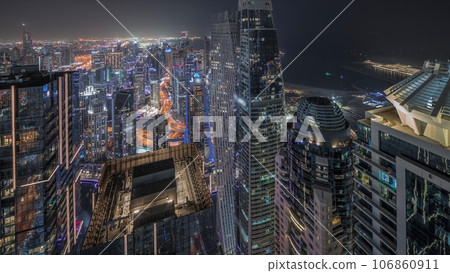 Panorama showing Dubai Marina and JLT district with traffic on highway between skyscrapers aerial night timelapse. 106860911