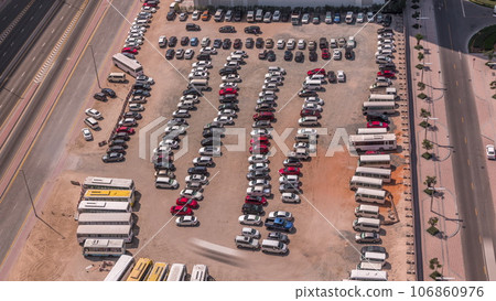 Aerial view of a parking lot with many cars in rows timelapse Aerial view of a parking lot with many cars in rows timelapse 106860976