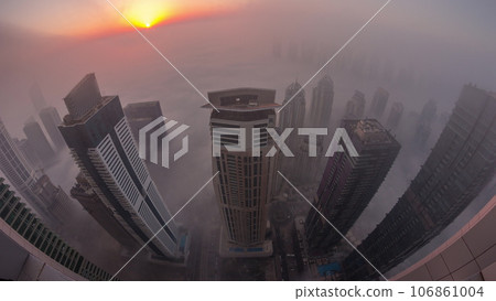 Rare early morning winter fog above the Dubai Marina skyline and skyscrapers lighted by street lights aerial night to day timelapse. 106861004