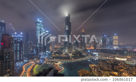 Skyscrapers rising above Dubai downtown all night timelapse surrounded by modern buildings aerial top view Skyscrapers rising above Dubai downtown all night timelapse surrounded by modern buildings aerial top view 106861017
