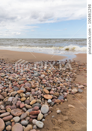 Coastal landscape with shore water and colorful pebble 106861298