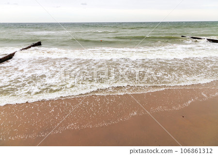 Seaside landscape with shore water and wooden breakwater 106861312