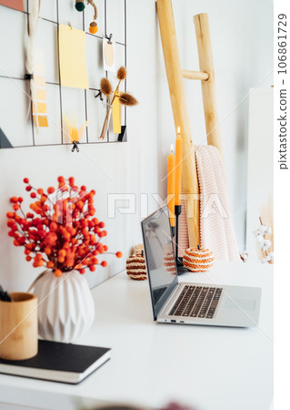 Home office desk with open laptop, seasonal decor like candles, flowers, pumpkins. grid mood board with fall colors palette. Autumn inspiration and cozy mood. Hygge home fall decor. Selective focus Home office desk with open laptop, seasonal decor like candles, flowers, pumpkins. grid mood board with fall colors palette. Autumn inspiration and cozy mood. Hygge home fall decor. Selective focus 106861729