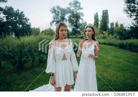 Two young women meditate and do yoga in nature. 106861957
