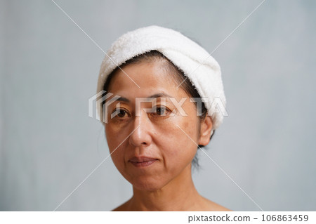 一位中年婦女，臉上衰老，有斑點和皺紋 106863459