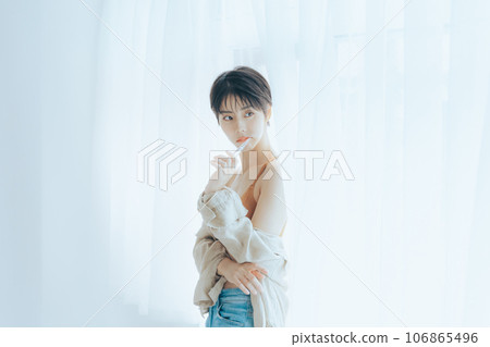 A woman looking outside in the morning sun 106865496