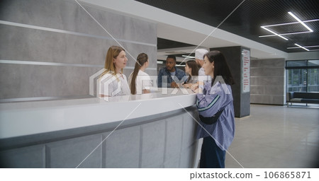 Adult woman stands at reception desk in clinic 106865871