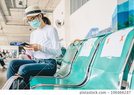 Tourist woman wearing mask while travel during the COVID-19 Pandemic. 106866287