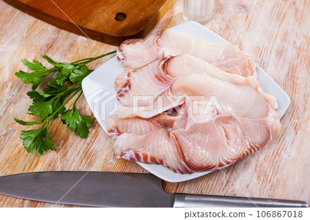 Raw blue shark steaks on wooden table with fresh parsley Raw blue shark steaks on wooden table with fresh parsley 106867018