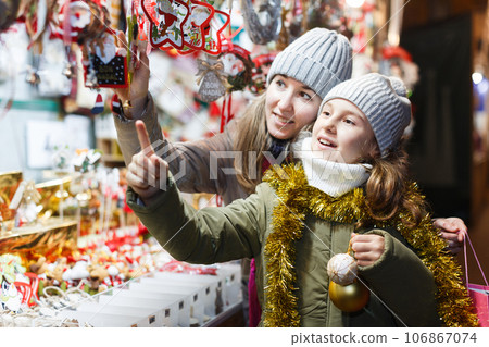 Smiling girl with woman are buying Christmas ornamentals 106867074