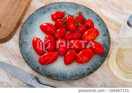 Fresh organic cherry tomatoes on wooden table Fresh organic cherry tomatoes on wooden table 106867135