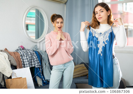Two young women choosing clothes to wear 106867306