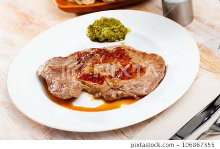 Prepared steak of beef with pesto sauce at plate 106867355