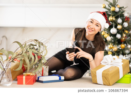 girl in santa hat with glass of wine is waiting for new year 106867394