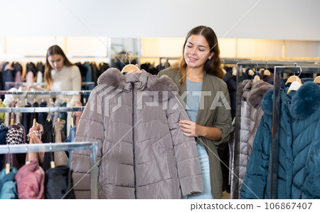 Young woman choosing insulated coat in store 106867407