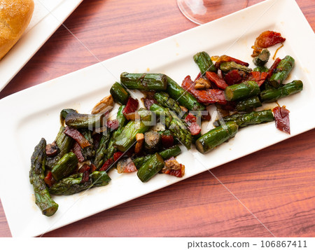 Grilled asparagus with ham and foie chips close up Grilled asparagus with ham and foie chips close up 106867411