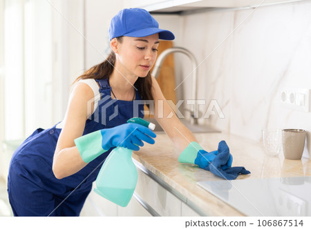 young positive girl is cleaning kitchen young positive girl is cleaning kitchen 106867514